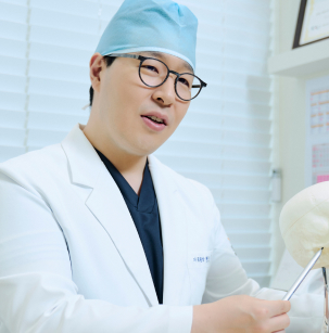 Главный врач Heal Dental Hospital в хирургической шапочке и белом халате